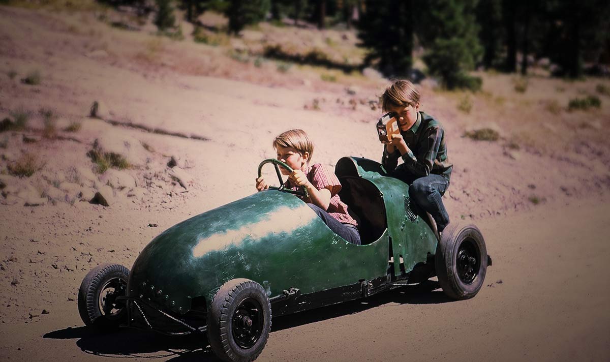 brothers on a down hill racer with super8 camera